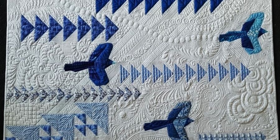 Flight path quilt with blue birds on white background