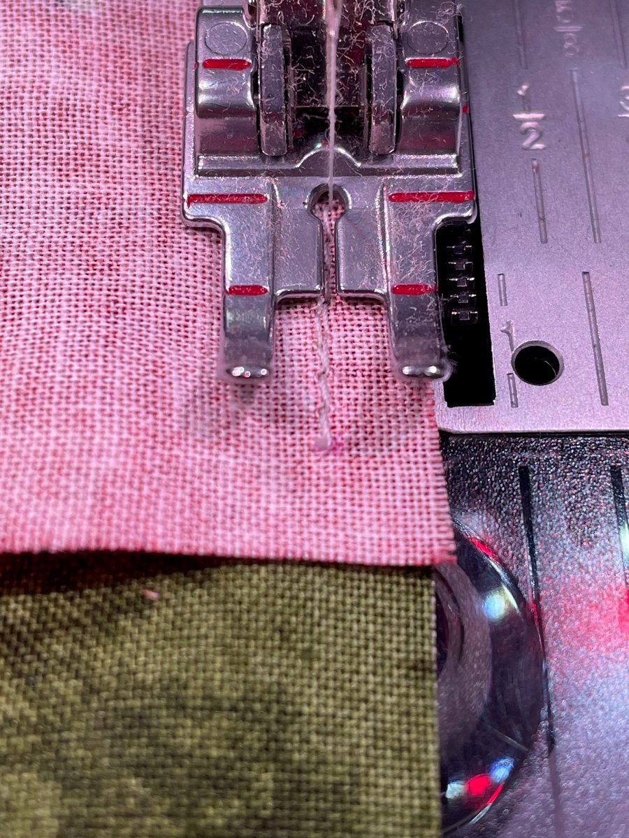 quilting machine foot on fabric performing backstitch