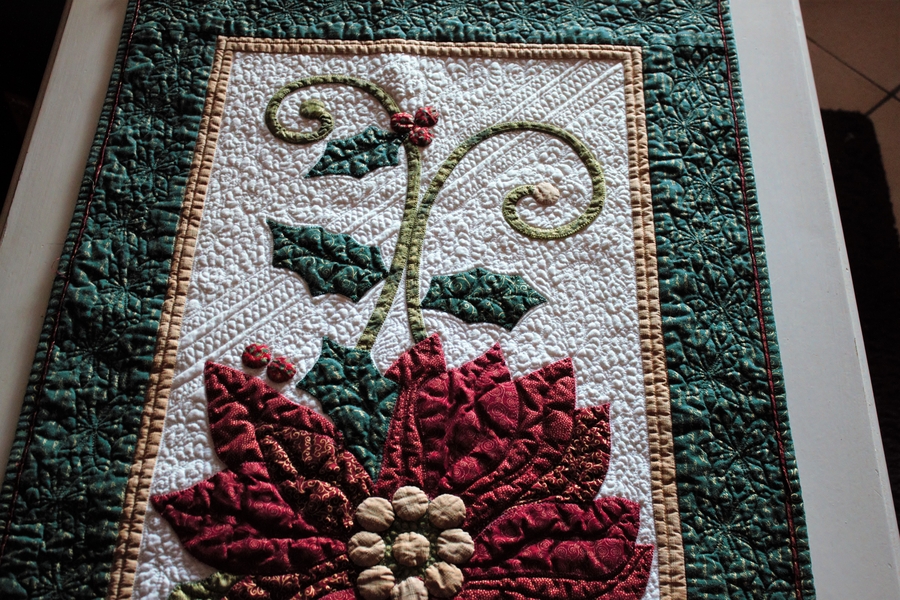close up of freehand quilting on traditional colors quilt